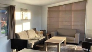 A modern living room with a sofa, a coffee table, and a TV. - Holiday Home in Brunssum With Terrace (Brunssum)