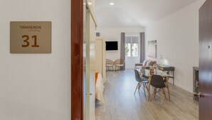 Un interno moderno con zona pranzo, divano e TV a parete.
