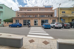 Un bâtiment avec une enseigne indiquant « Ristorante IL PORTOCIOLO » et un passage pour piétons devant.