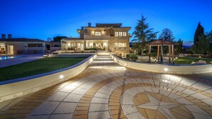 A large, multi-story house with a well-lit driveway and a pool. - The Villa Rallou Experience (Gazi)