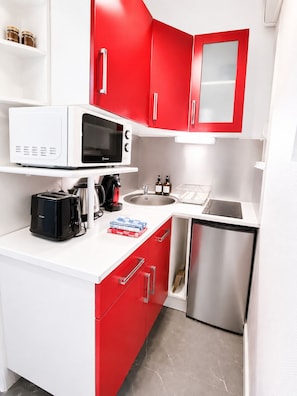A compact kitchen with a microwave, toaster, sink, and a small refrigerator. - Elegant | Studio | Downtown Nantes (Nantes)