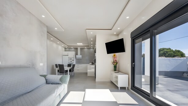 Habitación de hotel moderna con una cama grande, un escritorio, un televisor y vistas al exterior.