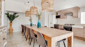 Eine moderne Küche mit einer Holztheke, Pendelleuchten und einem Blumentopf.