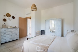 Une chambre à coucher comprenant un lit, une commode, une armoire et des éléments décoratifs sur le mur.