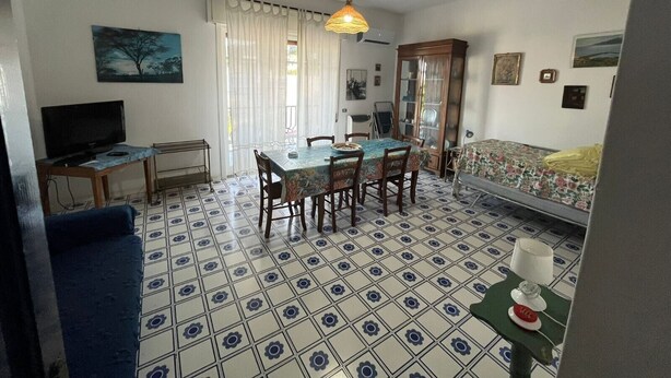 Une pièce comprenant une table à manger, des chaises, un téléviseur, un meuble et un lit.