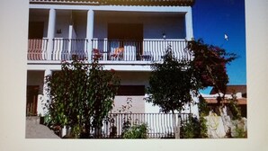 Un bâtiment à deux étages, doté de balcons, d’un toit plat et surplombant un ciel dégagé.