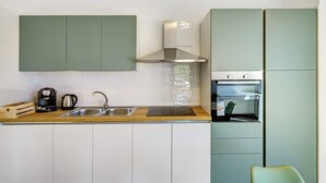 A kitchen with a sink, a stove, and cabinets. - Apartment 3 - Leucosia with Sea View, Private Terrace, and Air Conditioning (Casal Velino)