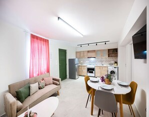Una cucina moderna con zona pranzo, divano e tavolo apparecchiato per due.