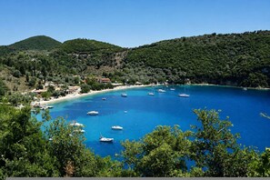 Una zona costiera con barche, una spiaggia e degli edifici.