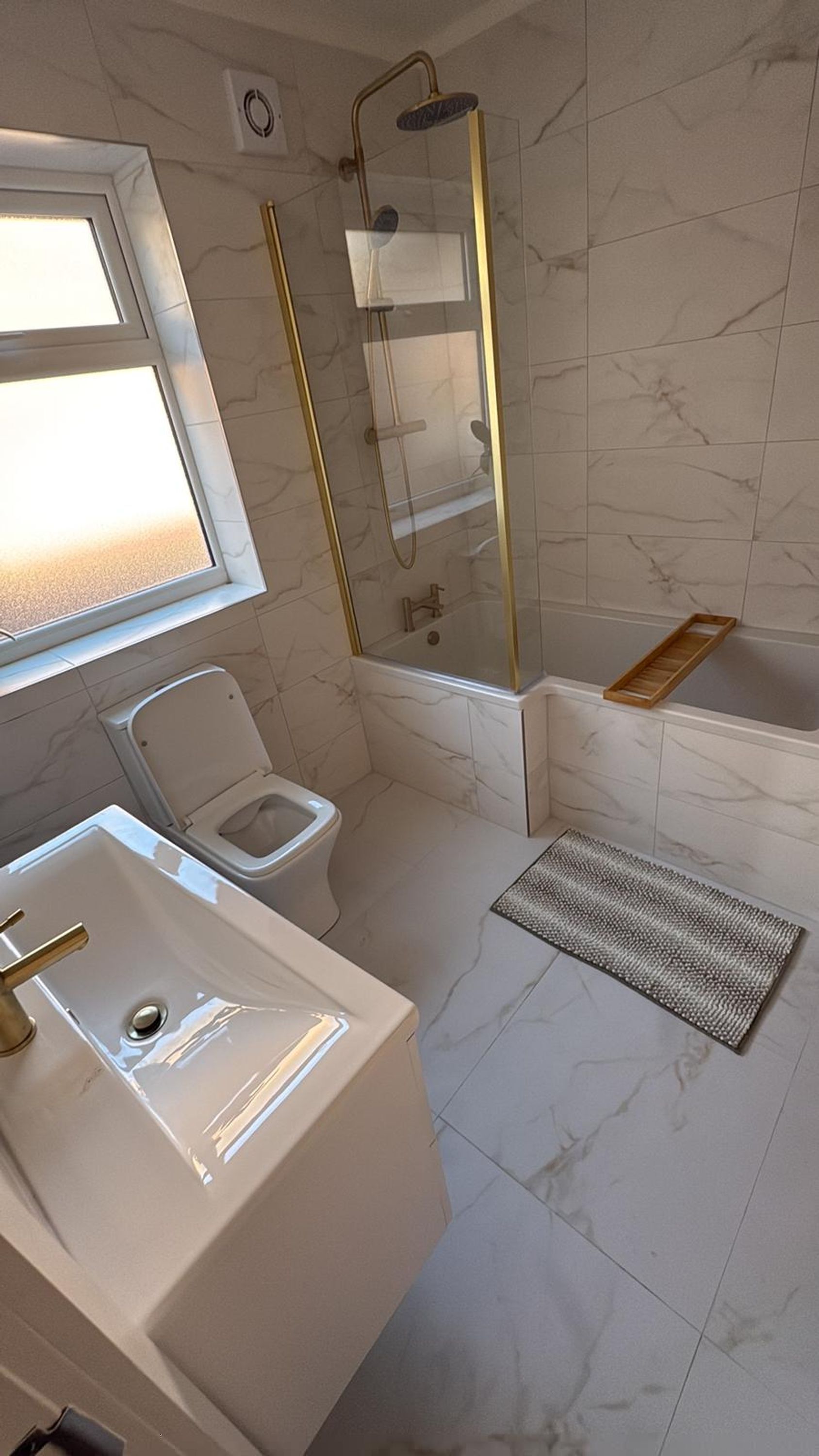 Een badkamer met toilet, wastafel, douche en bad.