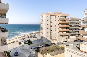 A coastal building with multiple balconies, a parking area, and a view of the sea. - Sea View Suite Eventi Felici Apartment with Terrace, Wi-Fi and Air Conditioning (Bari)