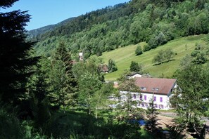 A rural house surrounded by lush greenery and hills. - Gîte l'Evasion, 20 to 35 Guests (Bussang)