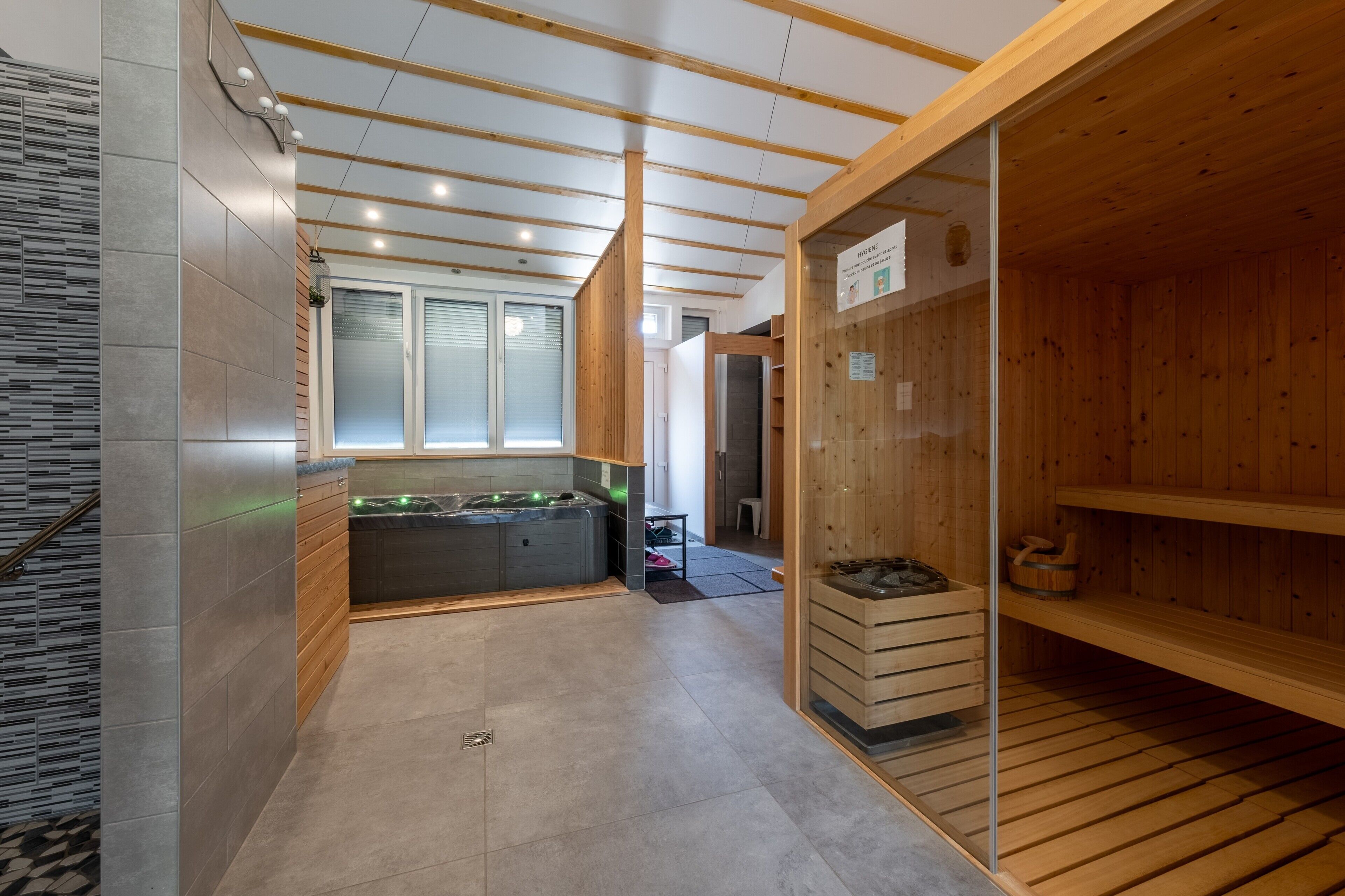 A sauna room with wooden benches and a hot tub.