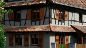 A traditional half-timbered house with multiple windows and a wooden gate. - Holiday Home “La Maison De Mediovilla” with Private Terrace, Garden & Wi-Fi (Wingersheim les Quatre Bans)