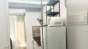 Une cuisine équipée d’un grand réfrigérateur, d’un four à micro-ondes et d’un évier.