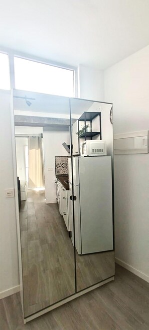Eine Küche mit einem großen Kühlschrank, einer Mikrowelle und einem Spülbecken.