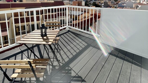 Une terrasse sur le toit offrant une vue sur la ville et les montagnes.