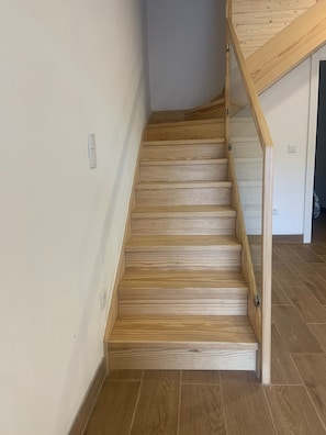 A wooden staircase with a handrail leading to an upper level. - House Near Mira de Aire Caves – Spacious and Family-Friendly (Mira de Aire)