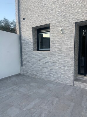 A modern building with a stone facade, a small window, and a door. - House Near Mira de Aire Caves – Spacious and Family-Friendly (Mira de Aire)