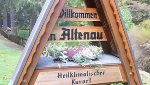 Ein Holzschild mit der Aufschrift 'Willkommen in Altenau' und 'Heilklimatischer Kurort'.