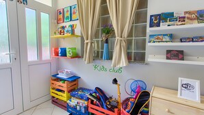A children's room with a 'Kids club' sign, storage crates, shelves with toys, and a 'Free WiFi' sign. - Apartment 'Daniela with Sea View' with Sea View, Wi-Fi and Air Conditioning (Porat)