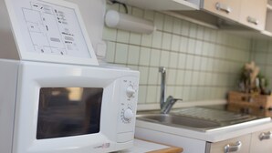 A kitchen with a microwave, wooden cabinets, a sink, and a tiled backsplash. - Apartment 'Daniela with Sea View' with Sea View, Wi-Fi and Air Conditioning (Porat)