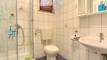 Un baño con inodoro, ducha y lavamanos.