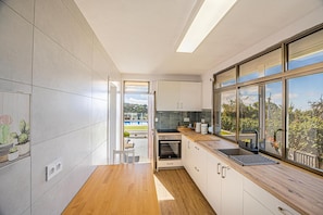 Una cocina moderna con un amplio ventanal, suelo de madera y vistas al exterior.