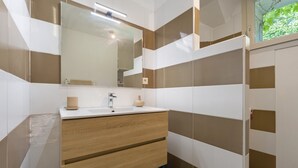Ein Badezimmer mit Spiegel, Waschbecken und Holzschrank.