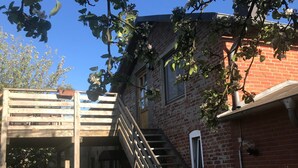 A brick building with a wooden staircase leading to a covered area.