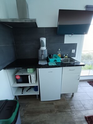 A compact kitchen with a microwave, a small refrigerator, and a sink. - Bungalow 'Private House Ocean View - 2' with Shared Pool, Garden and Wi-Fi (Gaula)