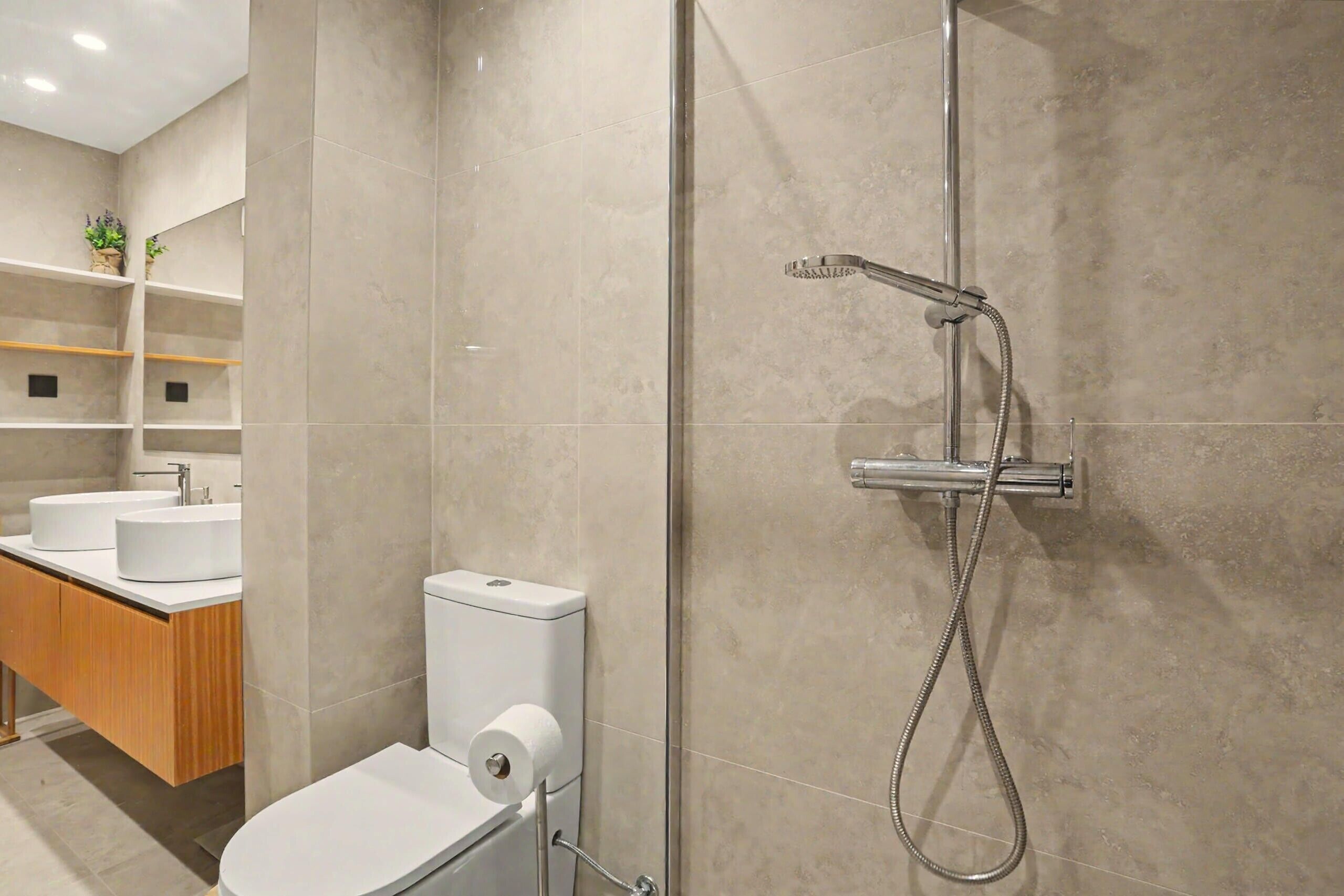 Un baño moderno con inodoro, lavamanos y ducha.