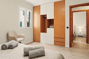 A bedroom with a bed, a chair, a wardrobe, and a nightstand. - Apartment 'Ninho Ilhéu' with Mountain View and Wi-Fi (Câmara de Lobos)