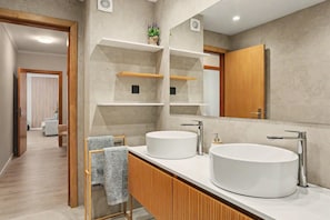 A modern bathroom with two sinks, wooden cabinets, and a large mirror. - Apartment 'Ninho Ilhéu' with Mountain View and Wi-Fi (Câmara de Lobos)