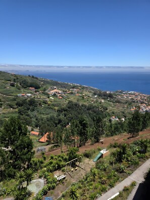 Eine Küstenstadt mit Häusern, Grünflächen und freiem Blick auf das Meer.