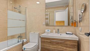 Un baño moderno con bañera, inodoro y tocador.