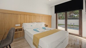 Una camera da letto moderna con una testiera in legno, un letto con biancheria da letto bianca, un comodino e una sedia.
