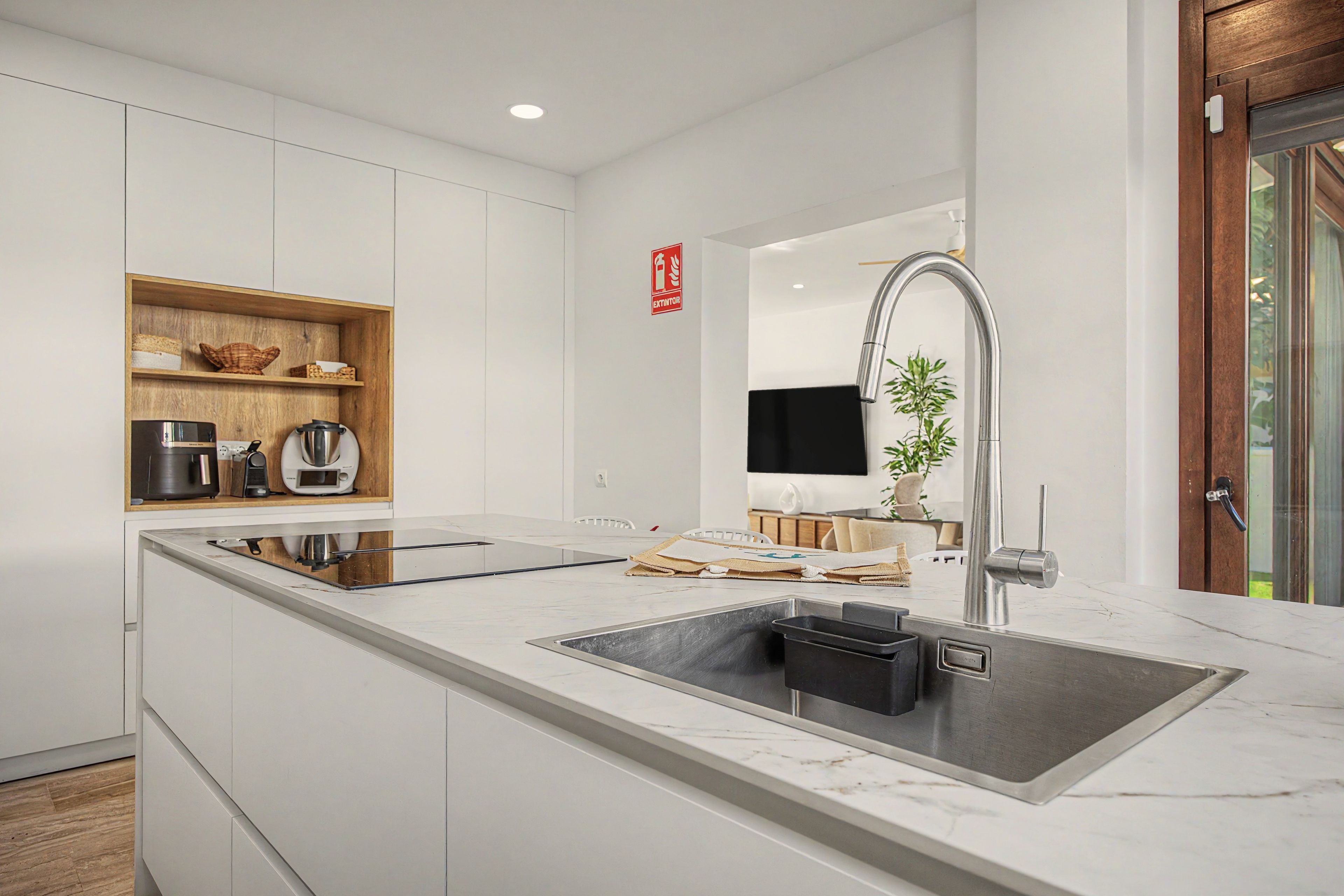 Una cocina moderna con una isla grande, electrodomésticos de acero inoxidable y un grifo elegante.