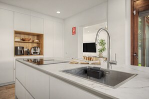 Eine moderne Küche mit einer großen Kochinsel, Edelstahlgeräten und einem eleganten Wasserhahn.