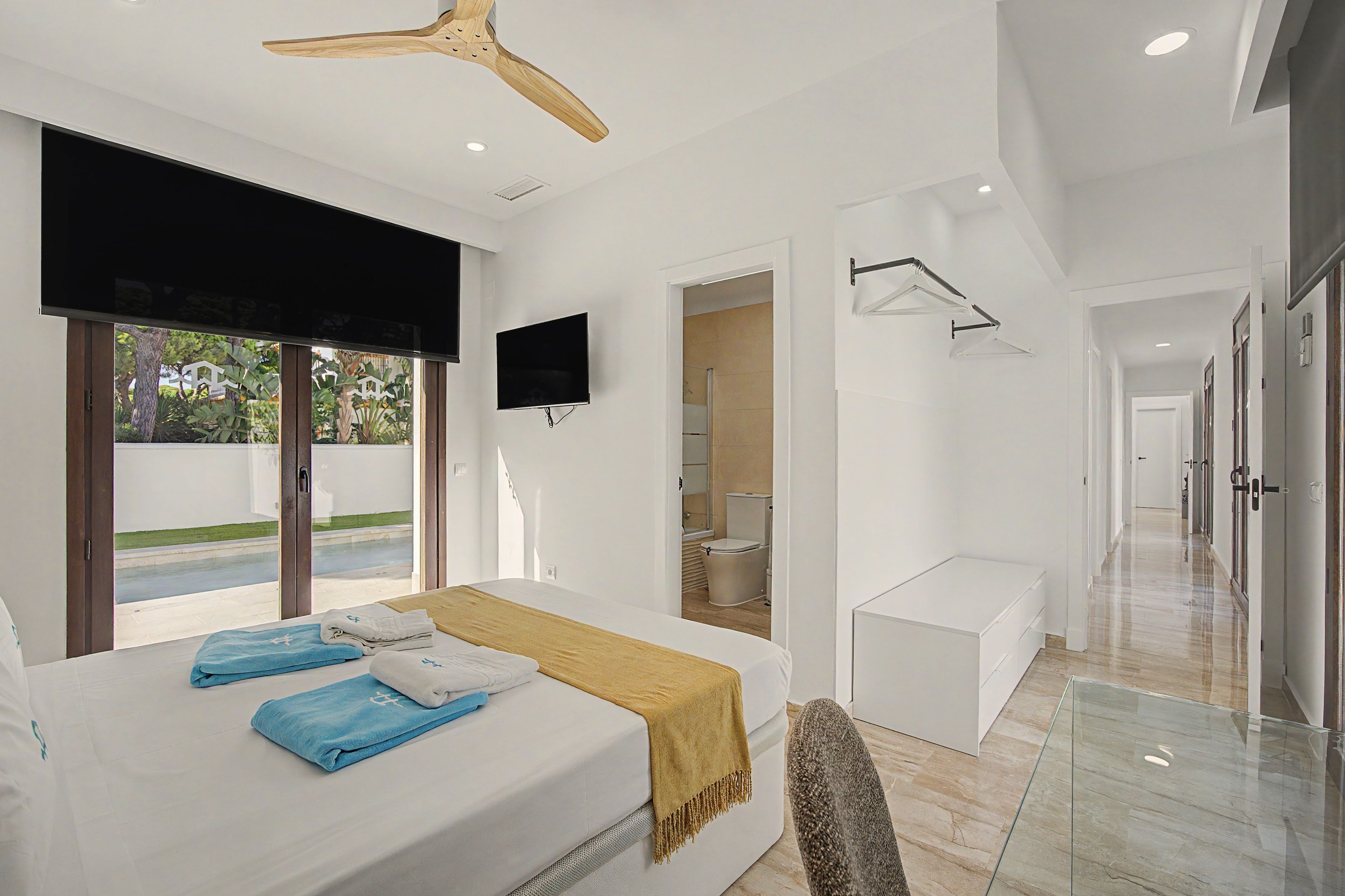 Een moderne hotelkamer met een groot bed, een flatscreen televisie en uitzicht op de omgeving.