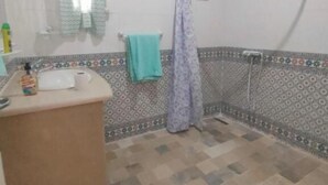 Un baño con ducha, lavabo y espejo.