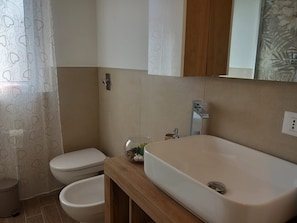 Ein Badezimmer mit Toilette, Bidet und Waschbecken.