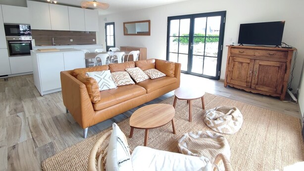 A modern living space with a sofa, coffee table, and a TV on a wooden cabinet. - Le 4 Pors Carn – walk to the beach, peaceful, sea view (Penmarch)