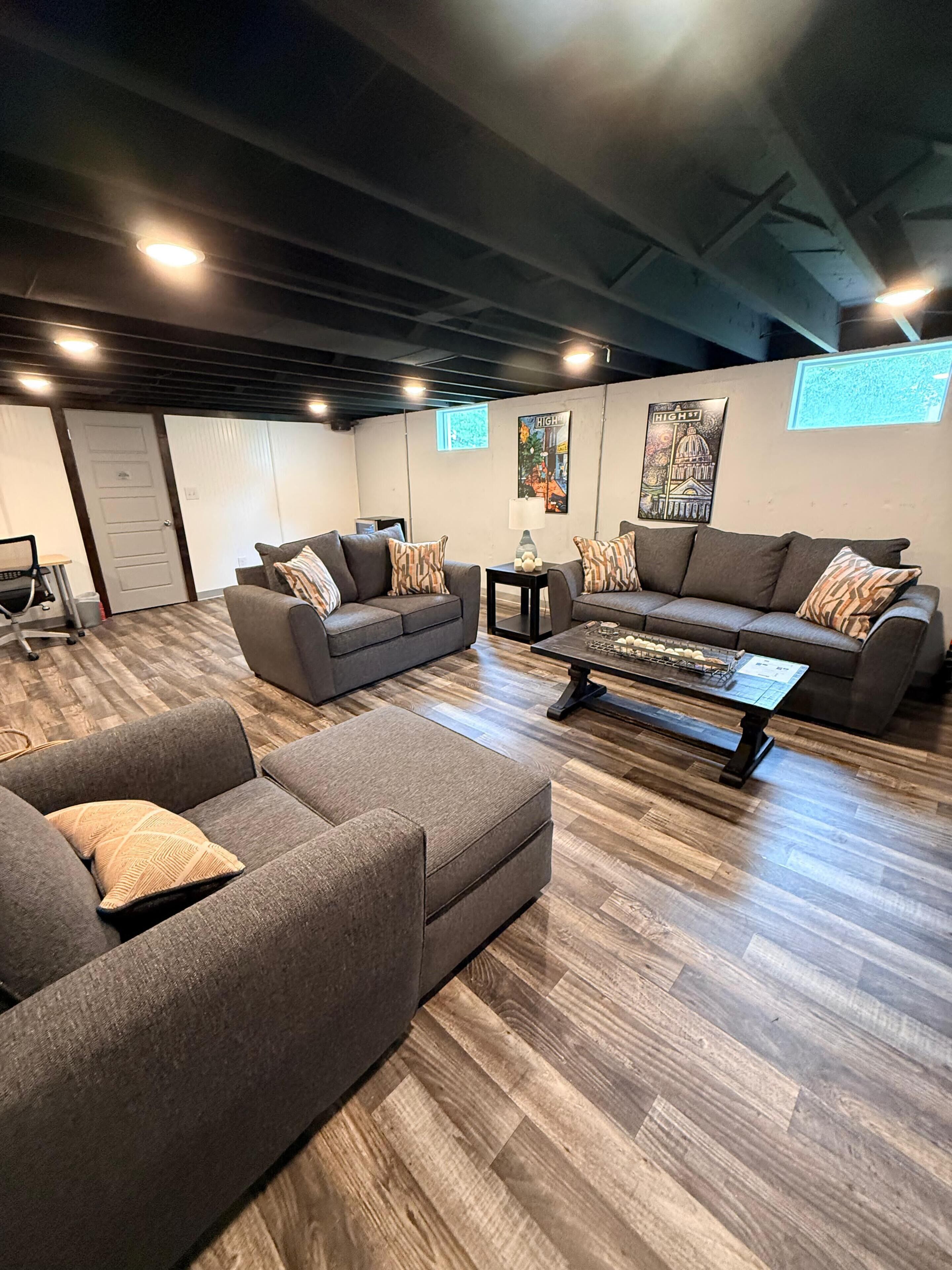 Un salon moderne avec un canapé d’angle, une table basse et une cheminée.