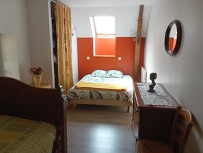 Una camera da letto con un letto, una scrivania, una sedia, uno specchio e una finestra.
