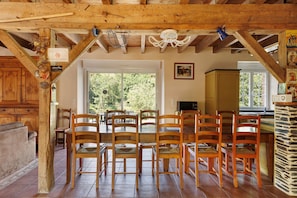 A rustic dining area with wooden chairs and a large window. - Gîte Le Relais Des Hirondelles: Lake View, Private Terrace & Wi-Fi (Segré-en-Anjou Bleu)