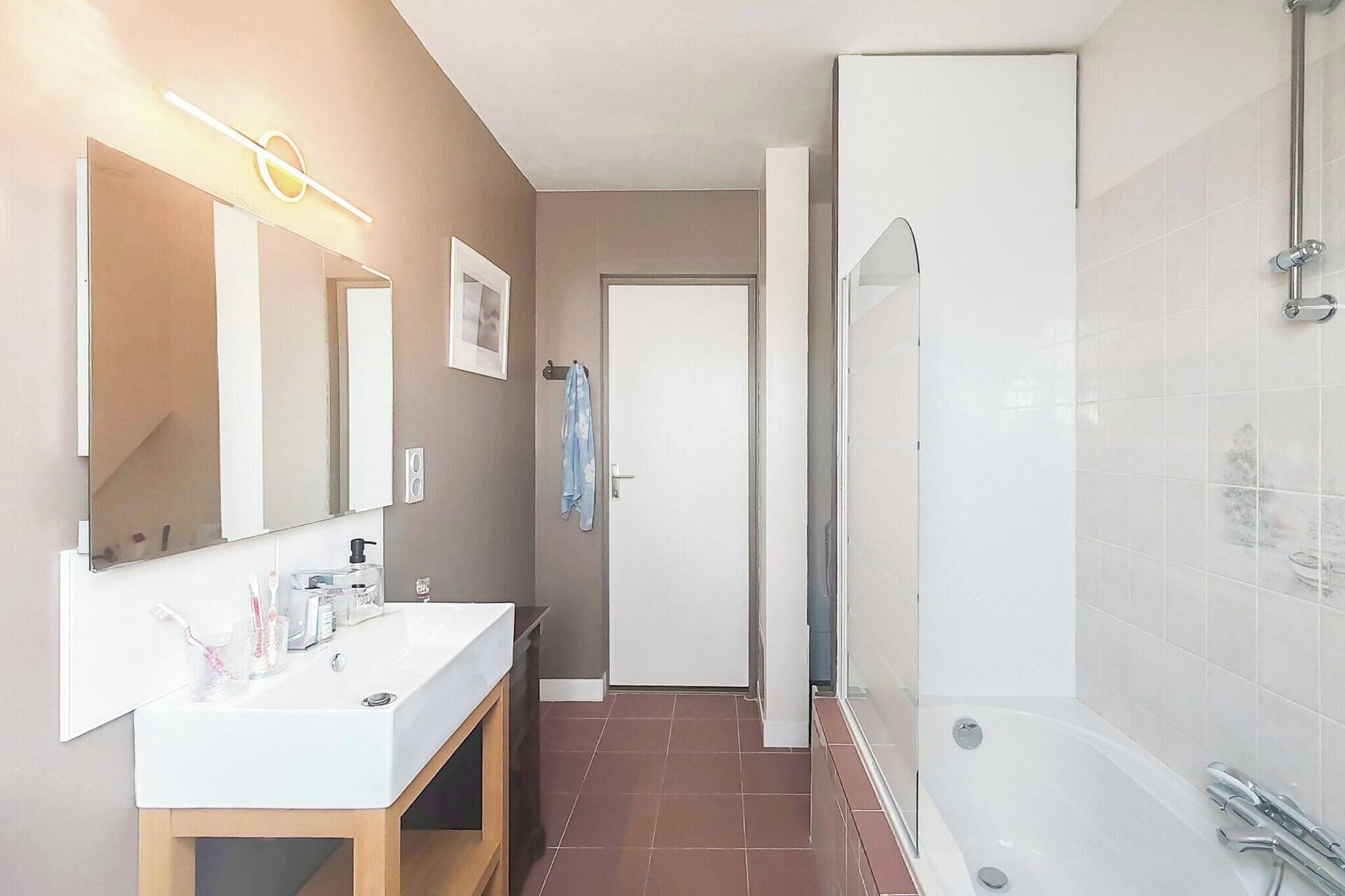 A modern bathroom with a sink, mirror, and shower.