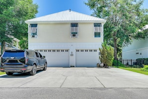 Ein zweistöckiges Haus mit Garage, Auffahrt und einem abgestellten Geländewagen.