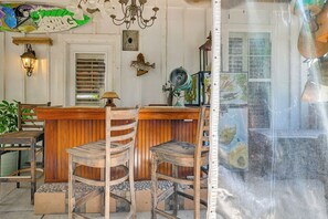Eine Bar mit hölzernen Barhocker, einem Chandelier und einer Wanddekoration mit Fischen.