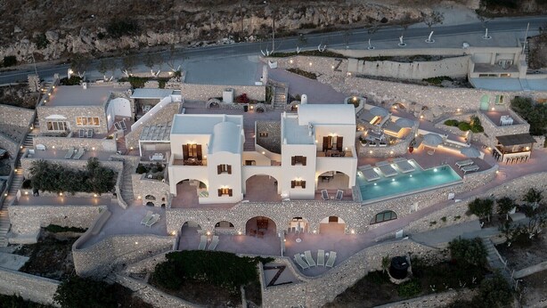 Et resort med flere bygninger, udesiddepladser og en swimmingpool.